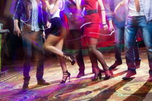 fötter av människor som dansar på en klubbfest.